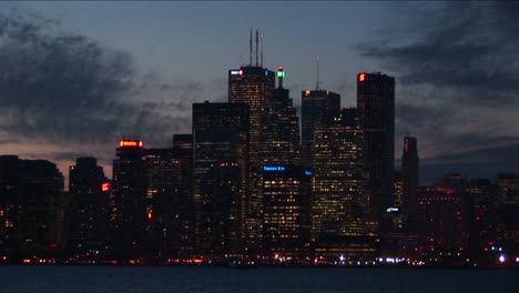 Toronto-Por-La-Noche-Con-Luces-Desde-El-Otro-Lado-Del-Lago-Ontario