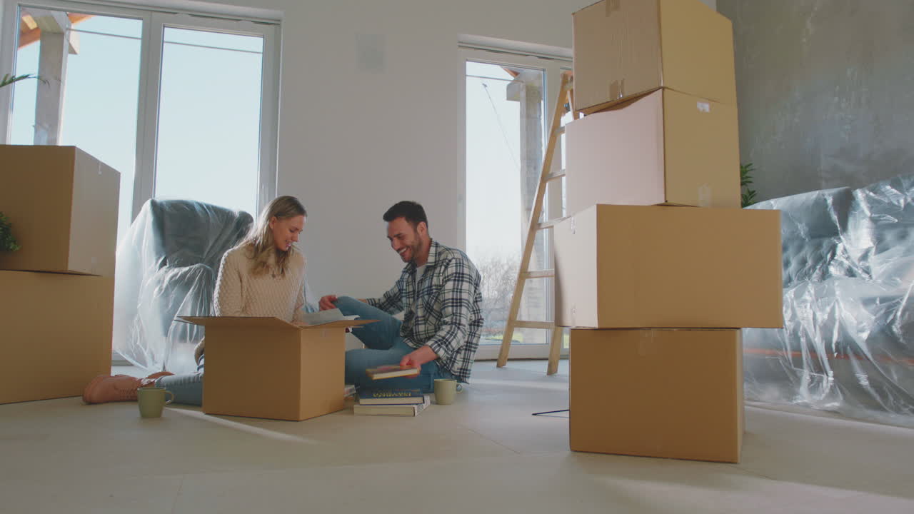 una pareja feliz desempaquetando cajas.