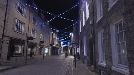 illuminated beautiful old street without people during winter lockdown in cambridge city centre england uk at night time