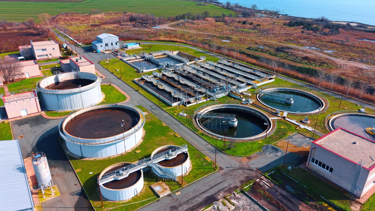 Modern water purification station near the coast. Wide aerial view of a complete water treatment complex with various tanks located by the sea