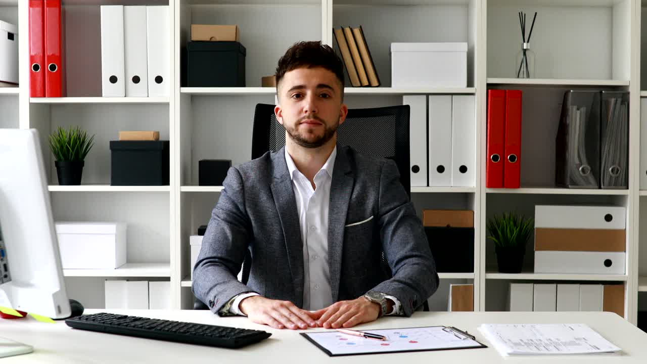 uomo d'affari sul posto di lavoro che guarda la telecamera