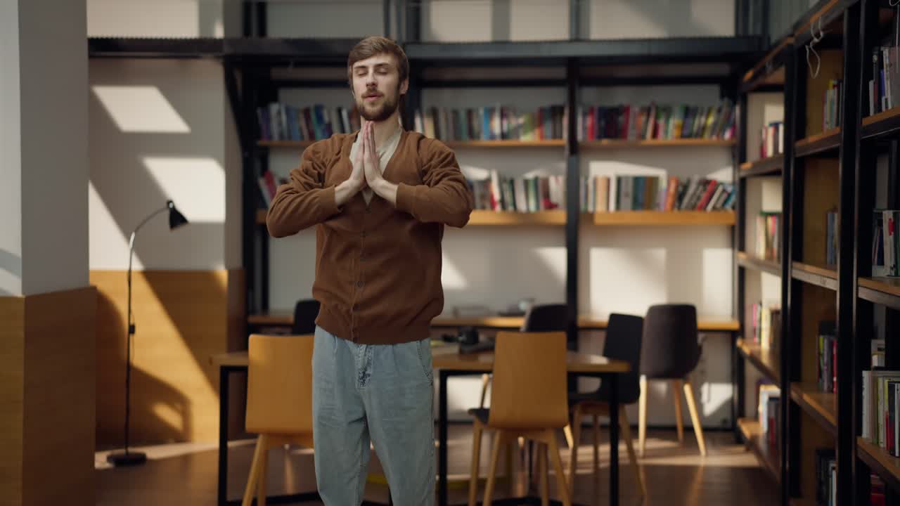 человек медитирует в библиотеке.