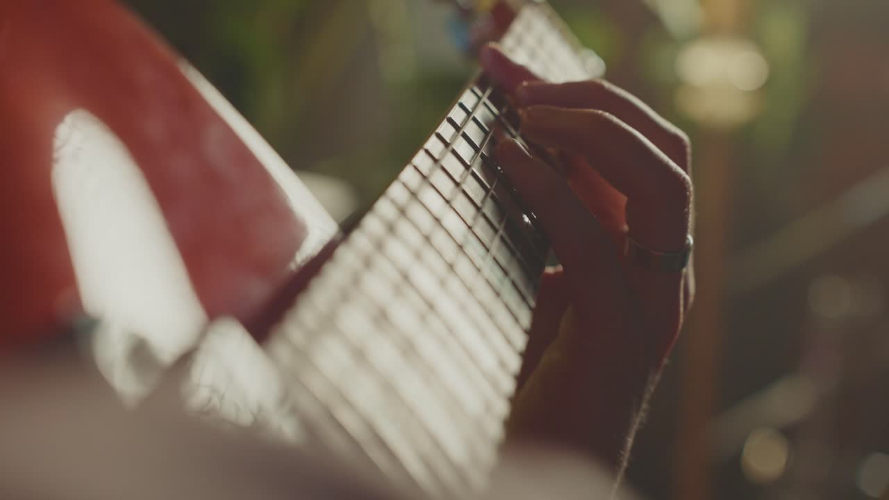 Close-up of a person playing a red guitar