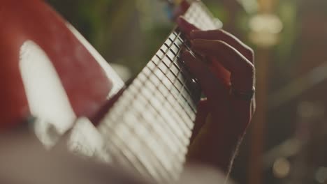 close-up of a person playing a red guitar