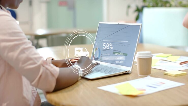 Woman tapping laptop, HUD showing ORD711N hitting95% peer giving mug pausing she resuming logistics
