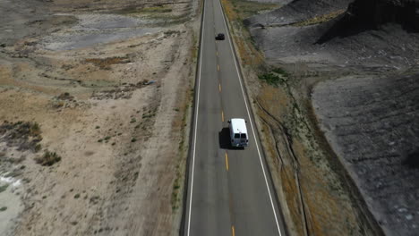 aerial view following traffic on a road, in middle of rock formations in southwest usa