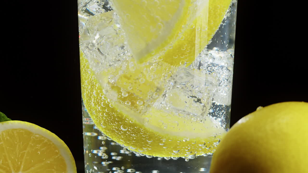 Acqua frizzante rinfrescante con fette di limone e cubetti di ghiaccio