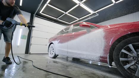 lava el coche con agua corriente y espuma.