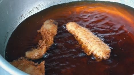 buñuelos de plátano fritos en aceite oscuro para comida callejera