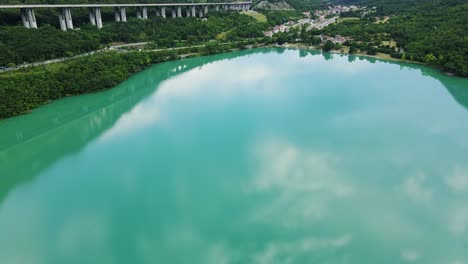 Serene establishing drone over Lago Morto with Alps and mirrored sky reflection