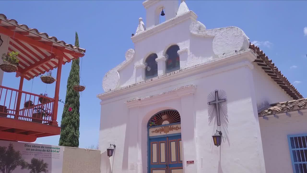 lento deslizamiento 4k toma de apertura de la iglesia y el cielo azul en verano, pueblo paisa