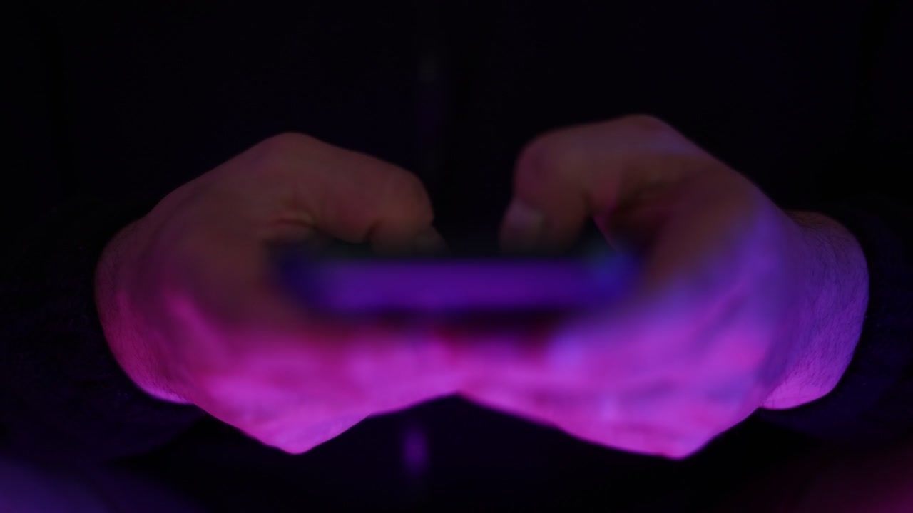 Filmato ravvicinato di mani che digitano un messaggio di testo su un touchscreen di smartphone con vista dall'alto