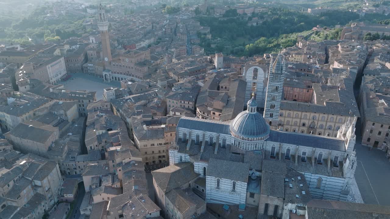vista aérea de alto ángulo del duomo de siena, la piazza del campo y la torre del mangia en siena, toscana, italia al amanecer con la ciudad medieval en 4k, girando en el sentido de las agujas del reloj