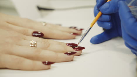 manicure concept. professional manicurist glues rhinestones on nails