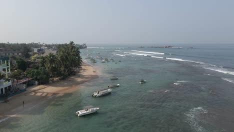 aerial descends to peaceful sand beach in hikkaduwa, sri lanka