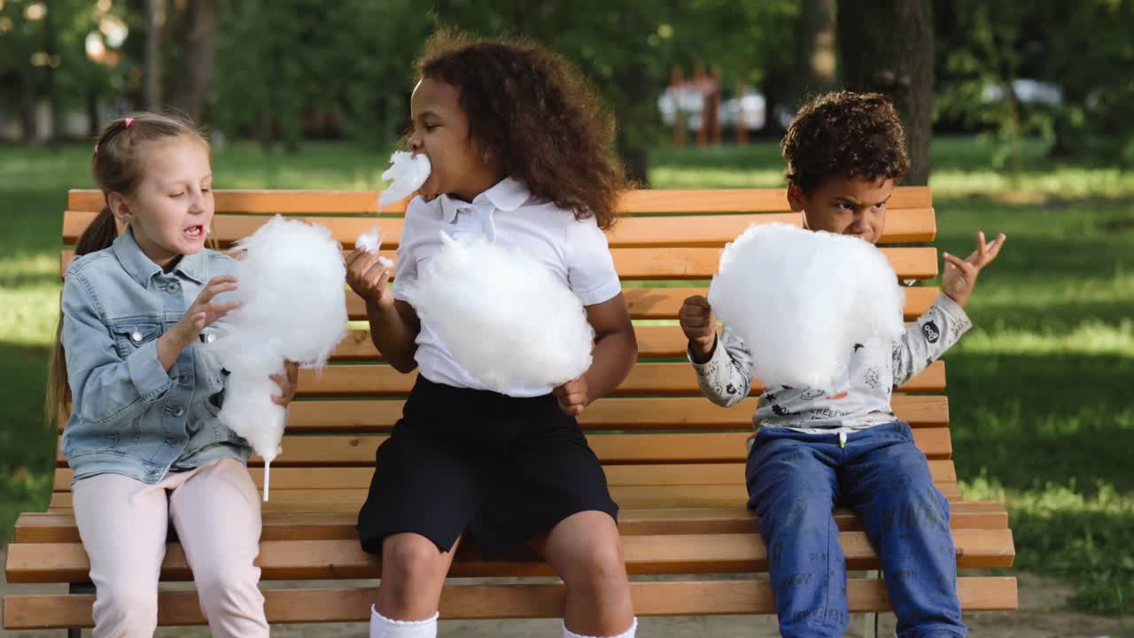 Children Eating Cotton Candy in a Park