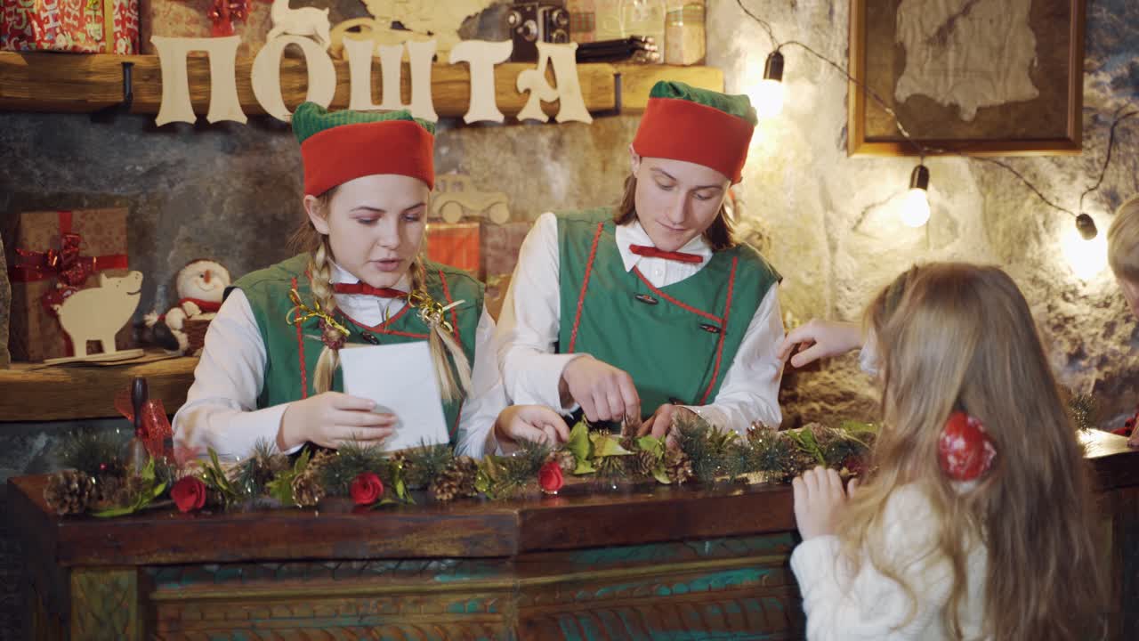 Sending letters for Santa Claus. Elves sending letters for Santa Claus together with children