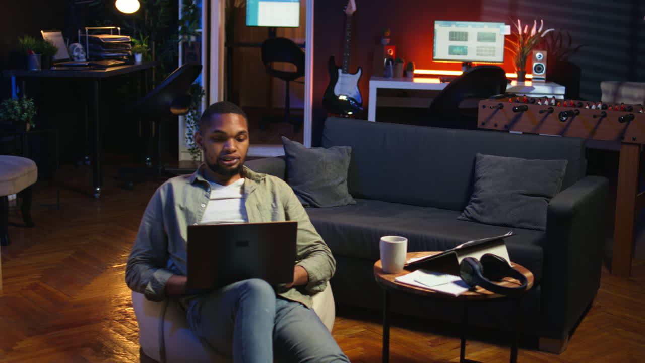 Vertical Video Young black person waving on remote video call on laptop sitting at home