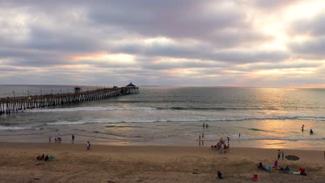 parches de luz solar que se reflejan en el agua del océano con olas en el muelle de la playa imperial en california al atardecer