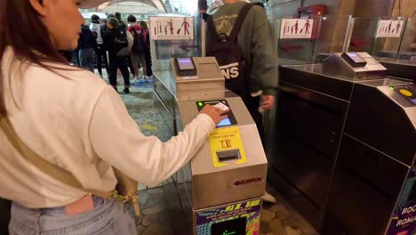 people using tap cards at metro turnstile