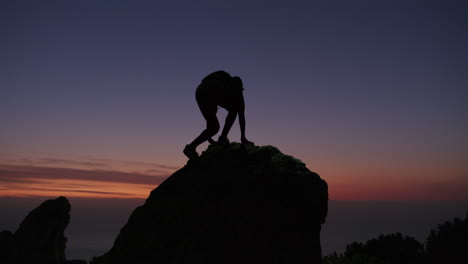 silhouette of hiker on mountain top at sunset