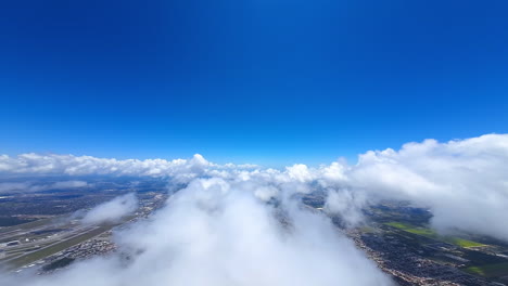 exciting flight above the fluffy white cloudscape. top view on the urban landscape of a huge metropolis. fpv drone footage.