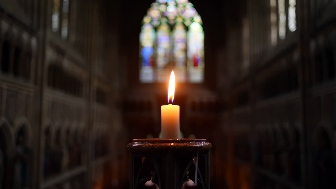 A Lit Candle in a Dark Church with Stained Glass Window
