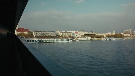view of bratislava’s riverfront with boats and historic buildings from a bridge