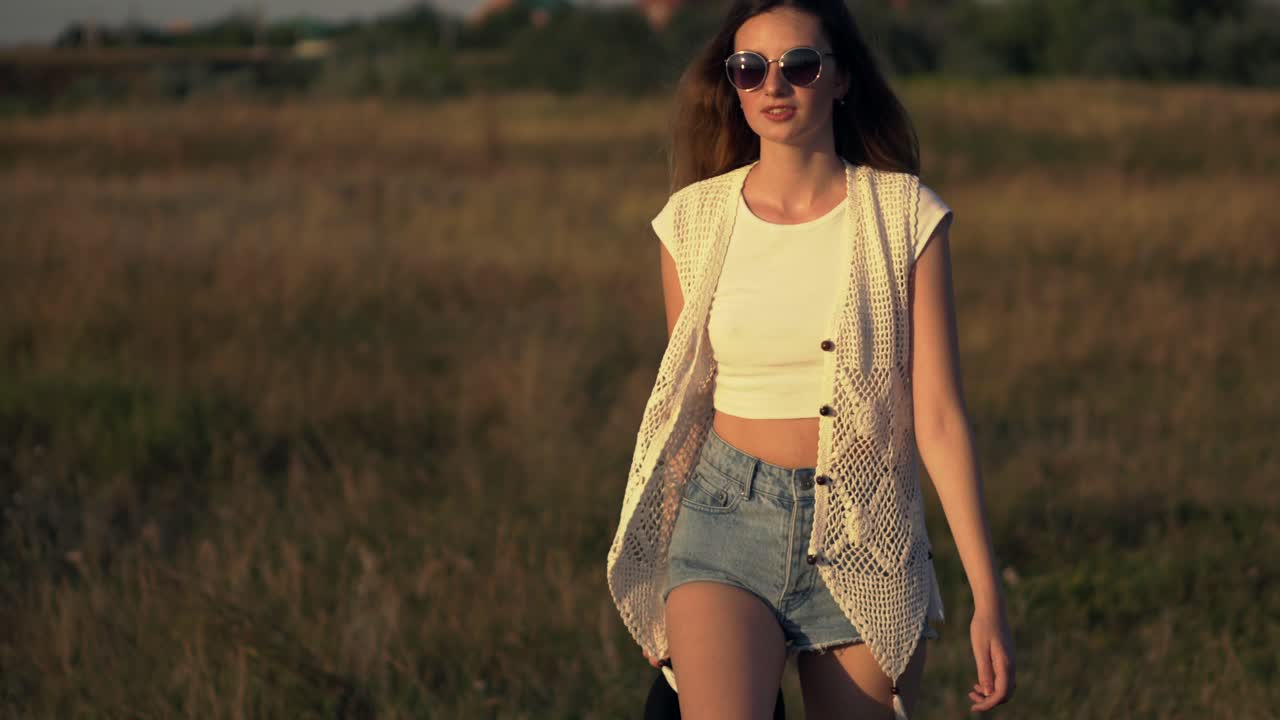 mujer caminando en un campo al atardecer