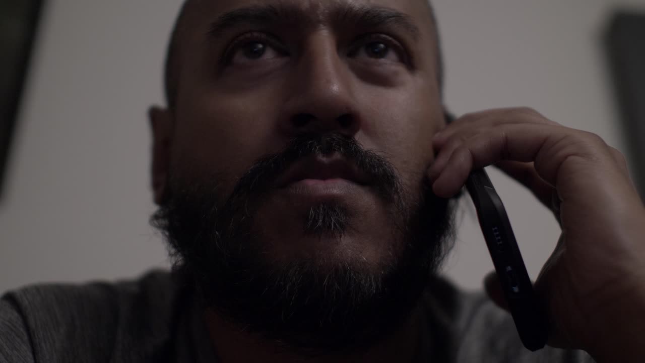Adult UK Asian Male Listening On Mobile Phone Indoors