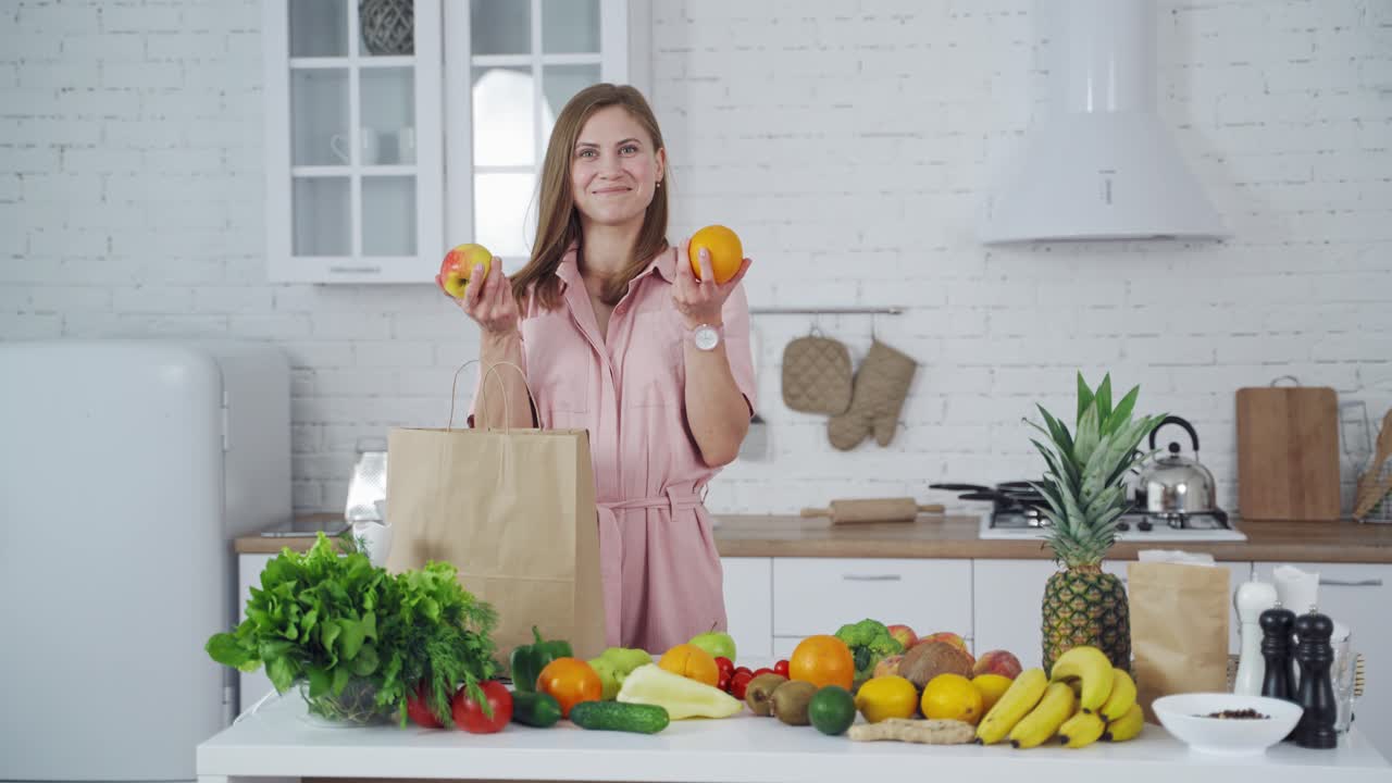 Woman unpacking grocery bag. Young woman with grocery shopping bag with fruits