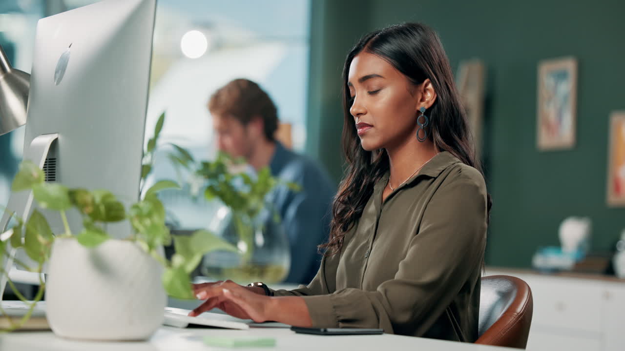 Frau mit Nackenschmerzen bei der Arbeit am Computer im Büro