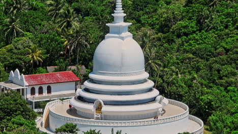 Unawatuna-Sri-Lanka-Luftaufnahme-V11-Nahaufnahme-Drohnenüberflug-Und-Um-Die-Japanische-Friedenspagode-Auf-Dem-Rumassala-Hügel-Versteckt-Zwischen-Den-Bäumen-Des-Regenwaldes-–-Aufgenommen-Mit-Mavic-3-Cine-–-April-2023