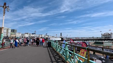 people strolling along brighton pier on a sunny day