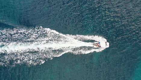 high-angle aerial motorboat creating whitewash on turquoise ocean