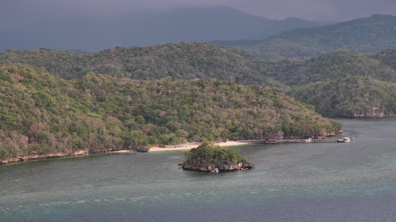 Aerial of small cove and heavy forested background. Gua Rangko, Labuan Bajo, Indonesia.