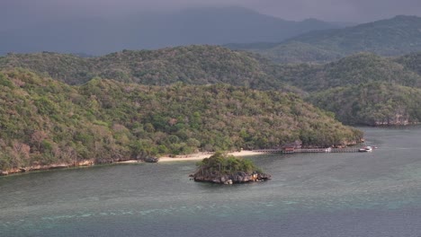 Aerial of small cove and heavy forested background. Gua Rangko, Labuan Bajo, Indonesia.