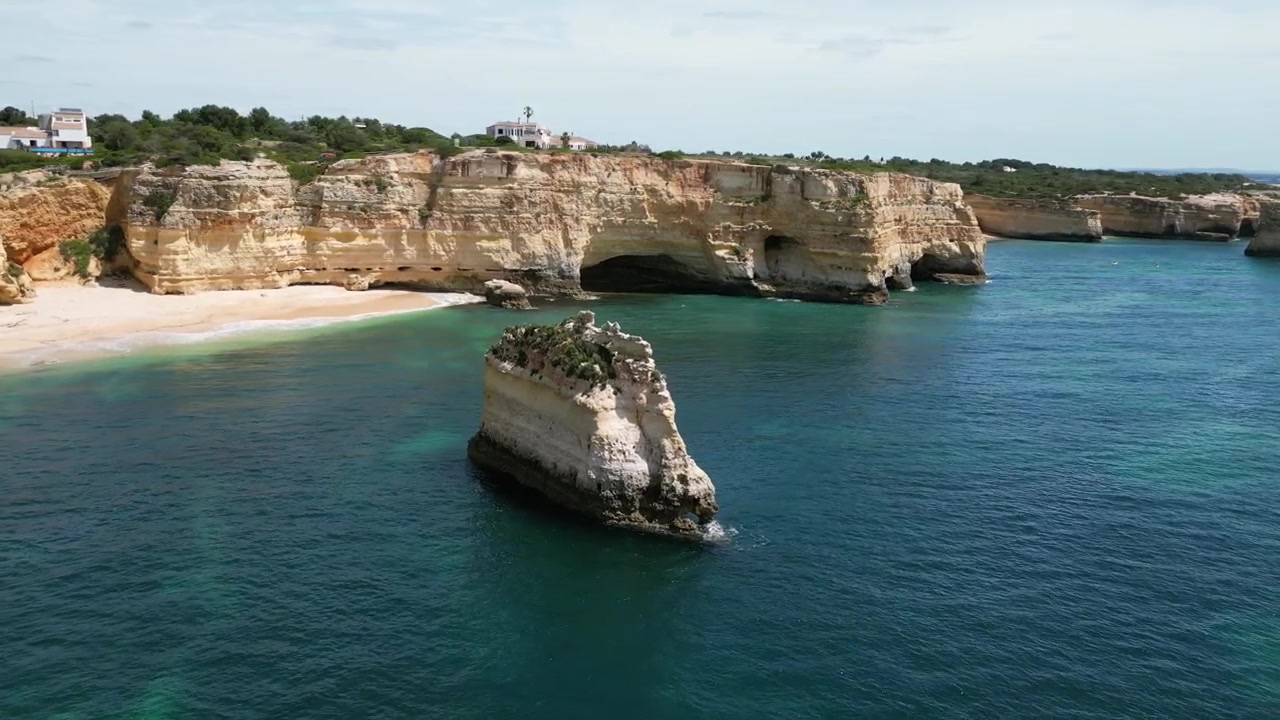 Riprese aeree con drone di Praia da Marinha, Portogallo: scogliere dorate, Oceano Atlantico e spettacolari formazioni rocciose costiere sotto la luce del sole. Ideale per progetti di viaggio e natura.