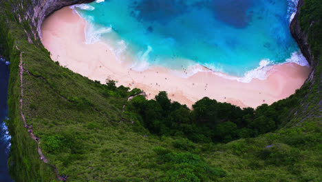 People-enjoying-turquoise-sea-waves-on-Kelingking-beach-in-Nusa-Penida