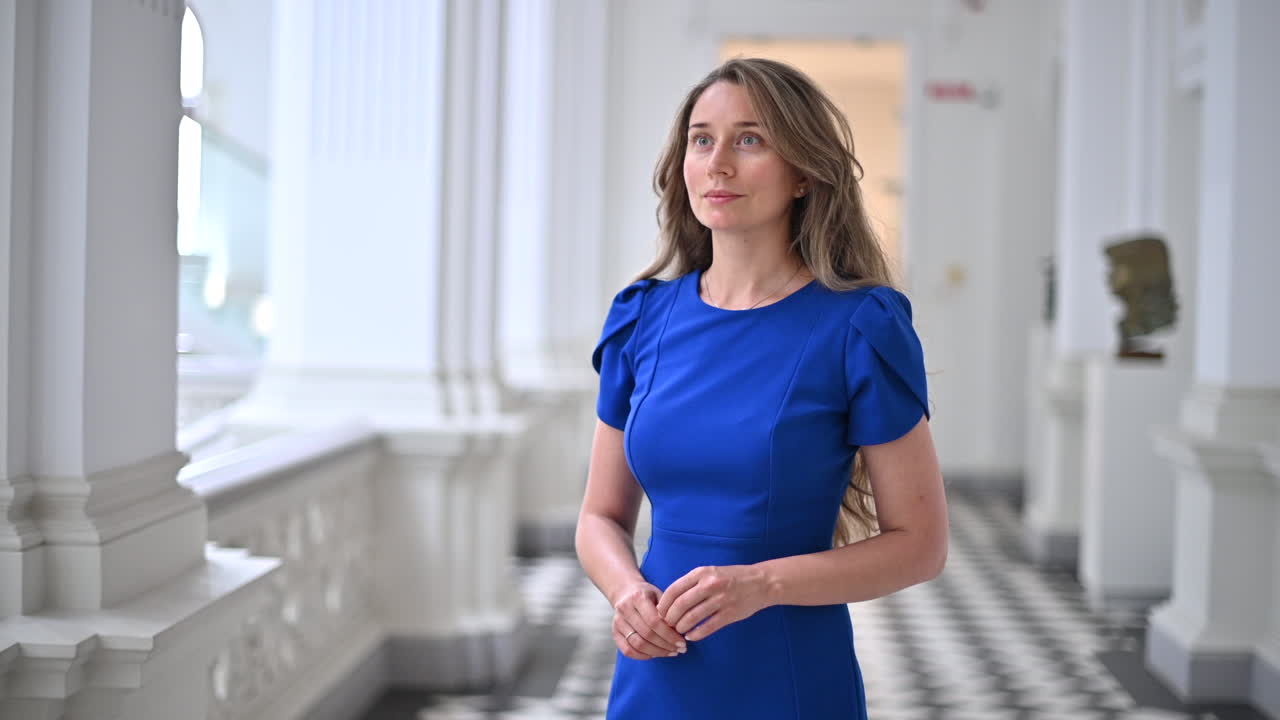 Donna bruna in abito blu che si muove nel Museo nazionale di belle arti di Chișinău, Moldavia