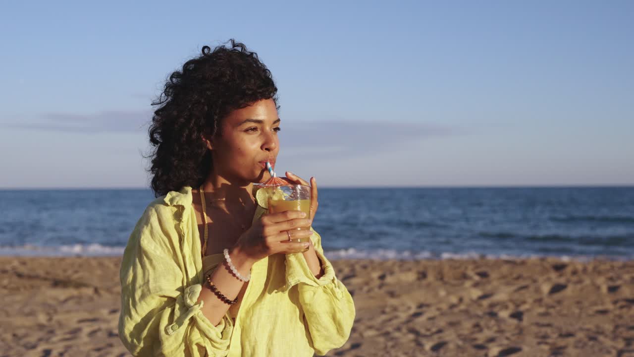 Woman drinking a cocktail on the beach