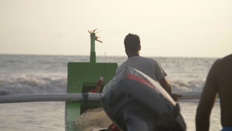 hombres guiando una canoa de pesca hacia el mar