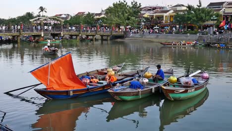 boatmen and boat ladies on standby for tours on the thu bon river at the old quarter in the city of hoi an, vietnam.