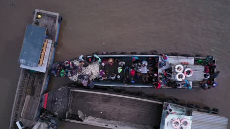 Aerial-view-of-maritime-workers-boarding-small-boats-at-Saigon-River-jetty,-Vietnam