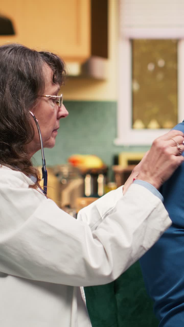 Vertical Video Physician uses stethoscope respiratory checkup routine with pensioner