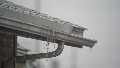 roof gutters overflowing during a heavy rain storm