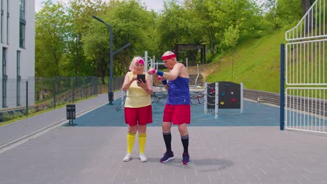 anciana abuela entrenadora enseñando al abuelo con deportes levantamiento de pesas ejercicios de fitness