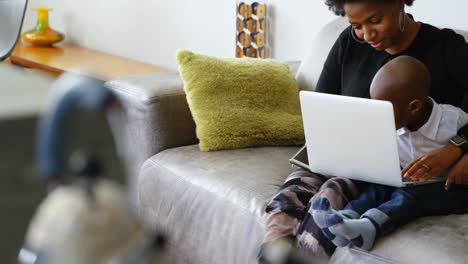 madre e hijo usando una computadora portátil en un hogar cómodo 4k