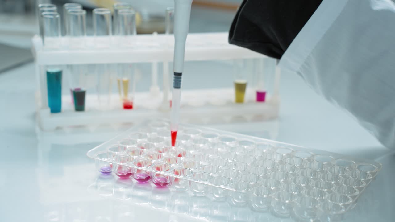 Lab Technician Performing Experiment Using Pipette and Well Plate