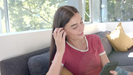 teenage caucasian girl with brown hair is smiling at her phone at home